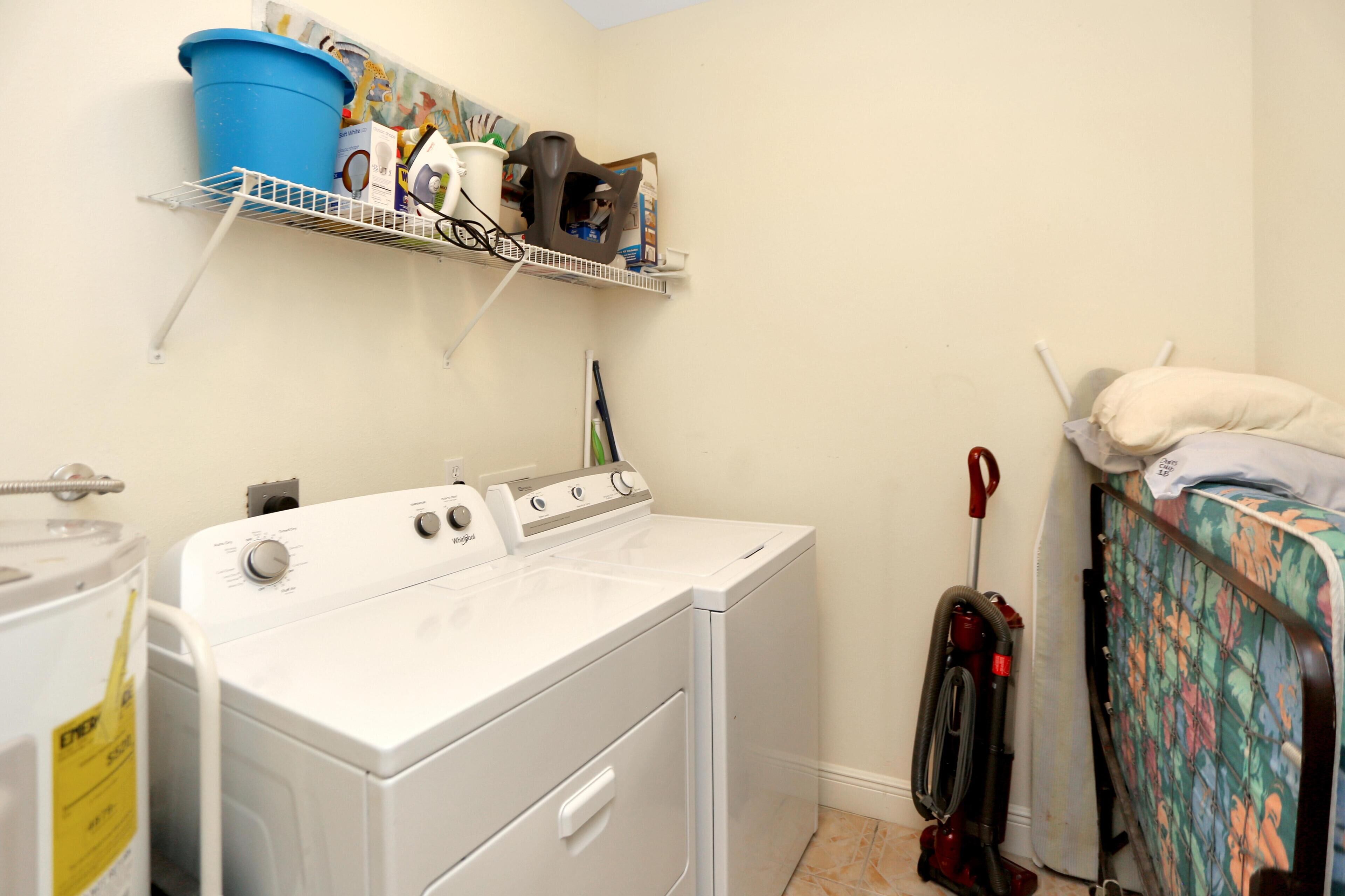 A laundry area with a washing machine, dryer, and a shelf with cleaning supplies.