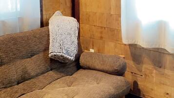 Une pièce chaleureuse avec un plafond en bois, un canapé et une tête d’animal empaillée accrochée au mur.