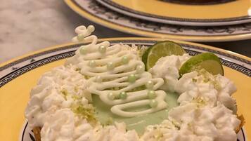 A dessert on a plate with whipped cream and lime slices.