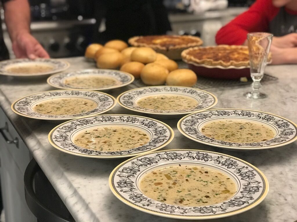 Ein Tisch mit Suppenteller und einem Korb mit Kartoffeln.