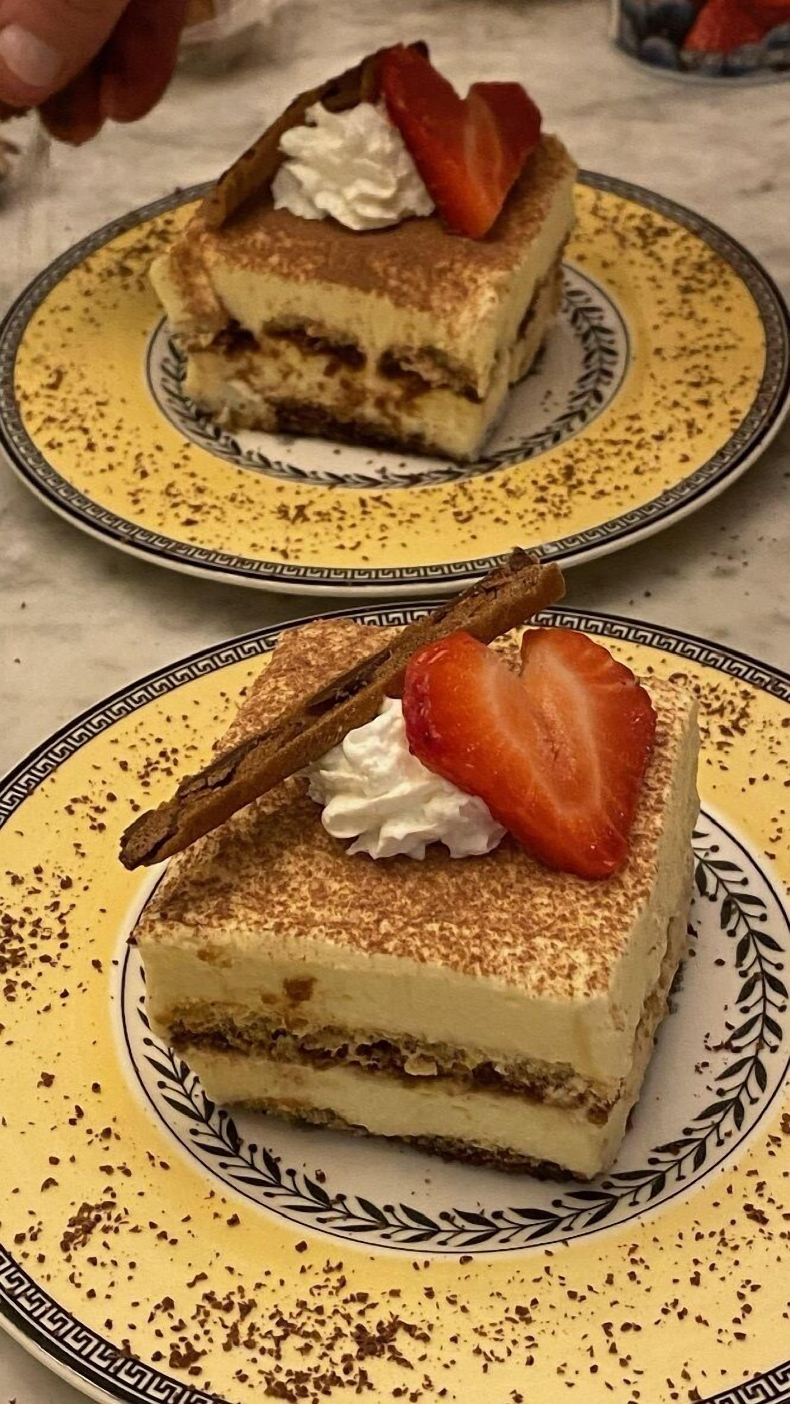 A dessert with a strawberry and whipped cream on a plate.