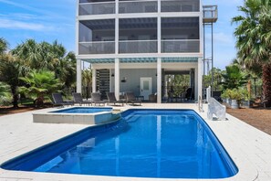 Guests can enjoy a balcony with a view of the pool area surrounded by lush greenery.