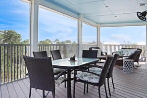Enjoy al fresco dining in this serene outdoor space with a table, chairs, and a charming view.