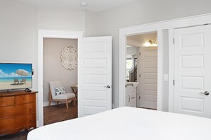 Relax in a spacious room with a large bed, flat-screen TV, and comfortable chair.
