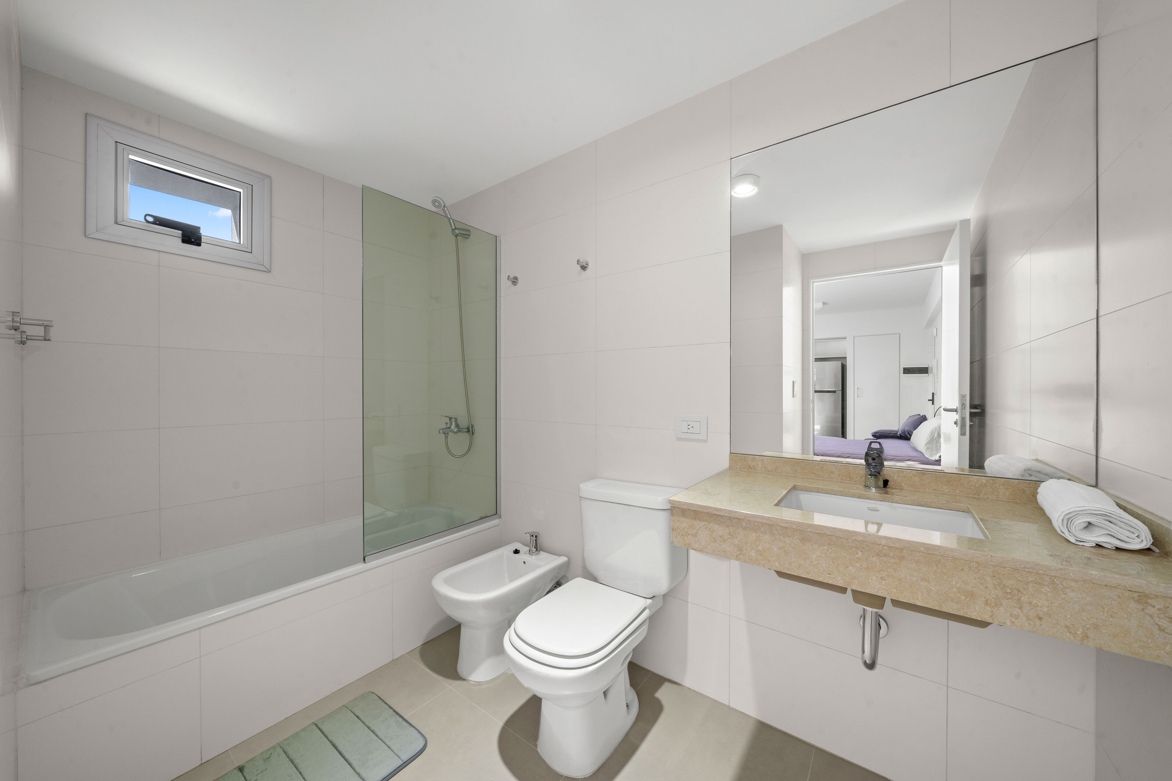 Un baño moderno con bañera, ducha, inodoro y lavamanos.