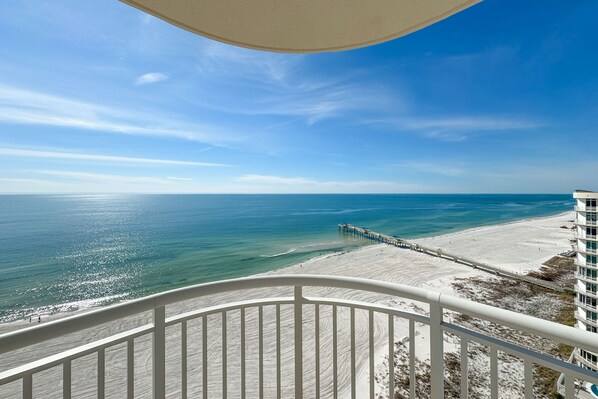 A balcony with a view of a beach and ocean.