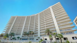 Um hotel de vários andares com design moderno, com varandas e um corredor central.