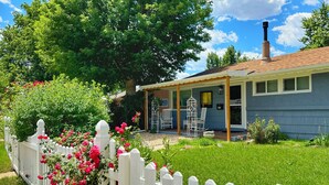 A house with a porch, a chimney, and a white picket fence. - ᨒ Hot Tub / Fire Pit / Game Lounge / Fenced Yard ᨒ (Colorado Springs)