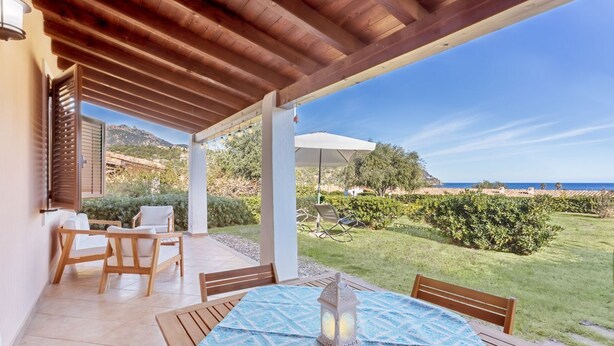 An outdoor patio with a table, chairs, and a view of the sea. - Casa Cactus Seaview with Pool (Tertenia)