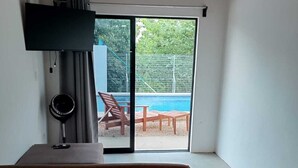 Quarto com uma grande porta de correr de vidro que dá para uma área de piscina externa.