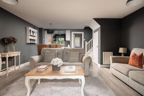 A living room with a sofa set, a coffee table, and a side table with decorative items.