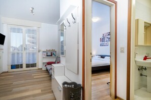Une chambre moderne comprenant un lit, un bureau, une chaise, une armoire et une salle de bain avec un lavabo.