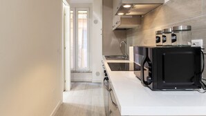 Une cuisine moderne équipée d’un four à micro-ondes, d’une cuisinière et de placards.