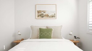 Een slaapkamer met een bed, twee nachtkastjes, een raam met jaloezieën en een lijst met een afbeelding aan de muur.