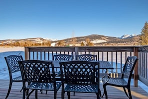 Terraza con mobiliario exterior y vista a montañas nevadas.