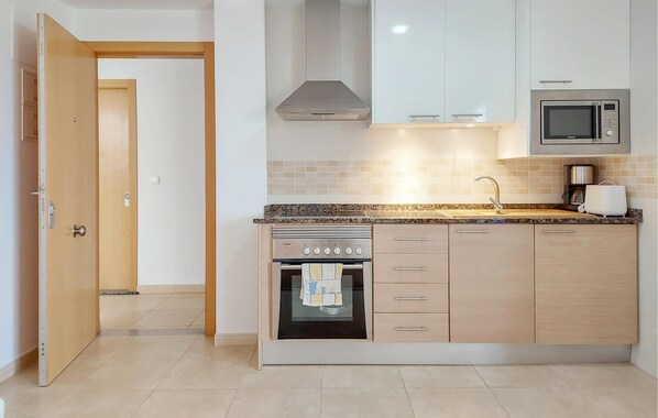 A modern kitchen with a built-in oven, microwave, and stainless steel cabinets. - Stunning apartment in Moncofa with house sea view (Moncofa)