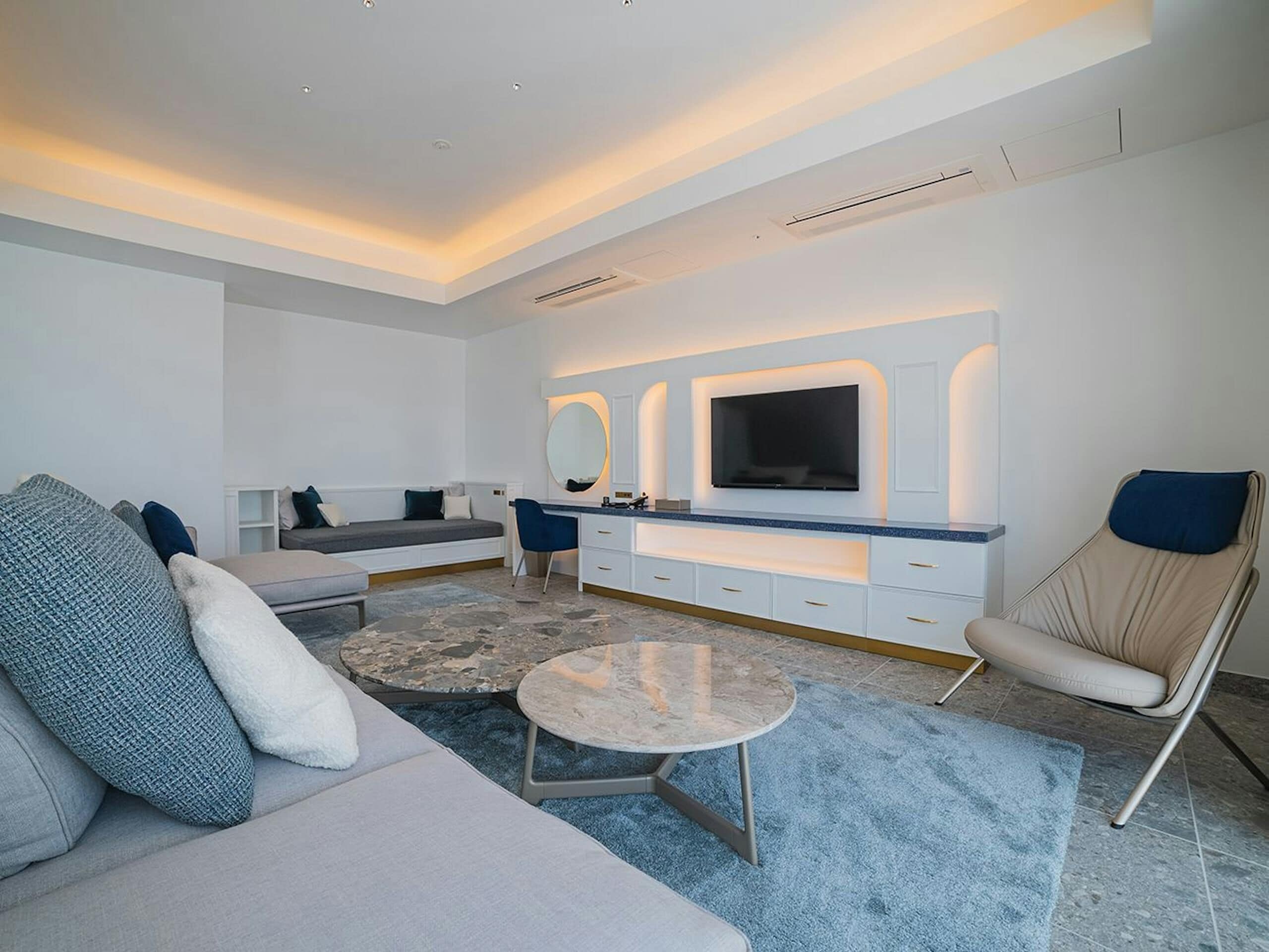 A modern living room with a sofa, a coffee table, a TV, and a chair.
