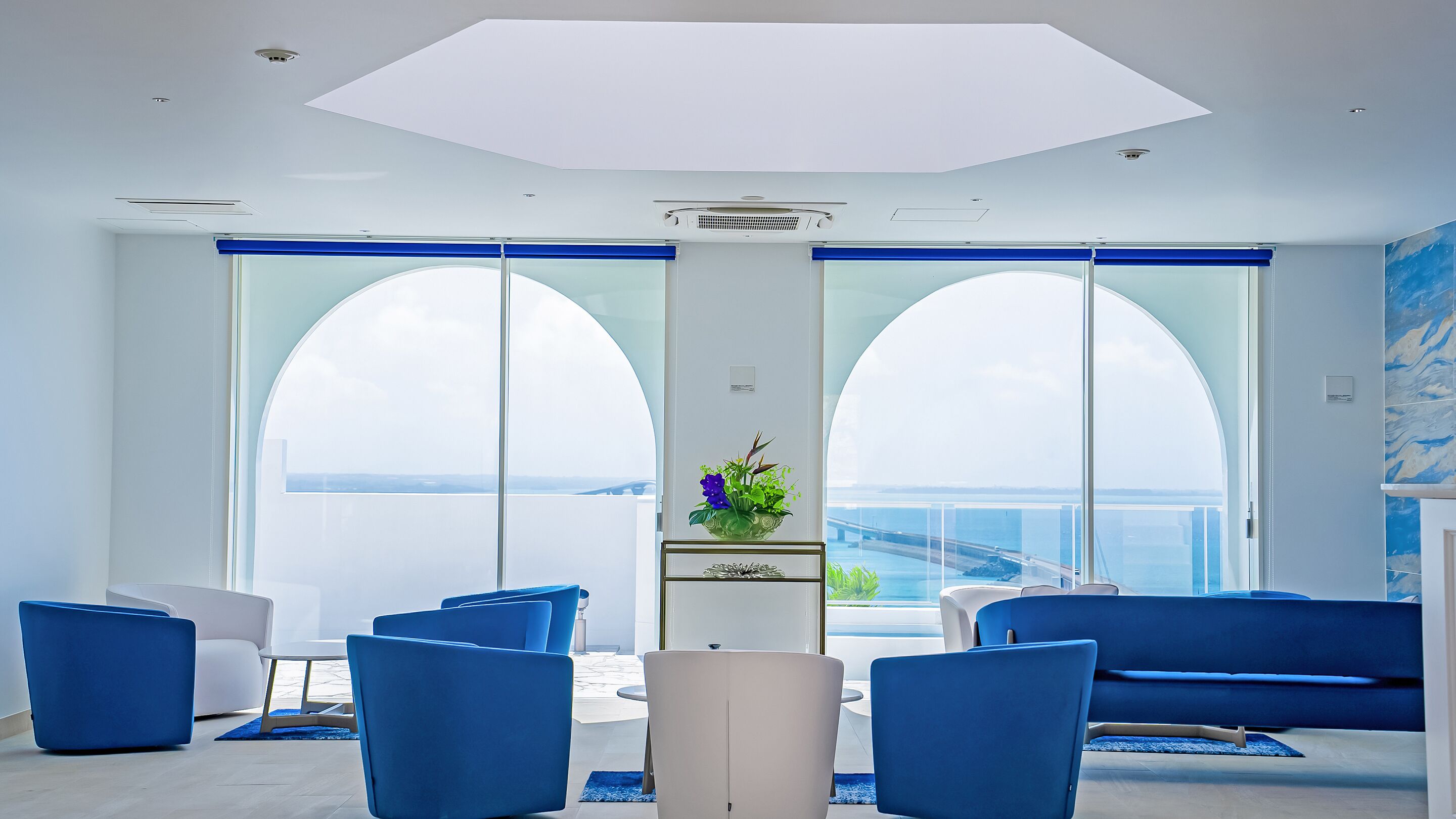 A modern room with a large window, a sofa, and a chair.