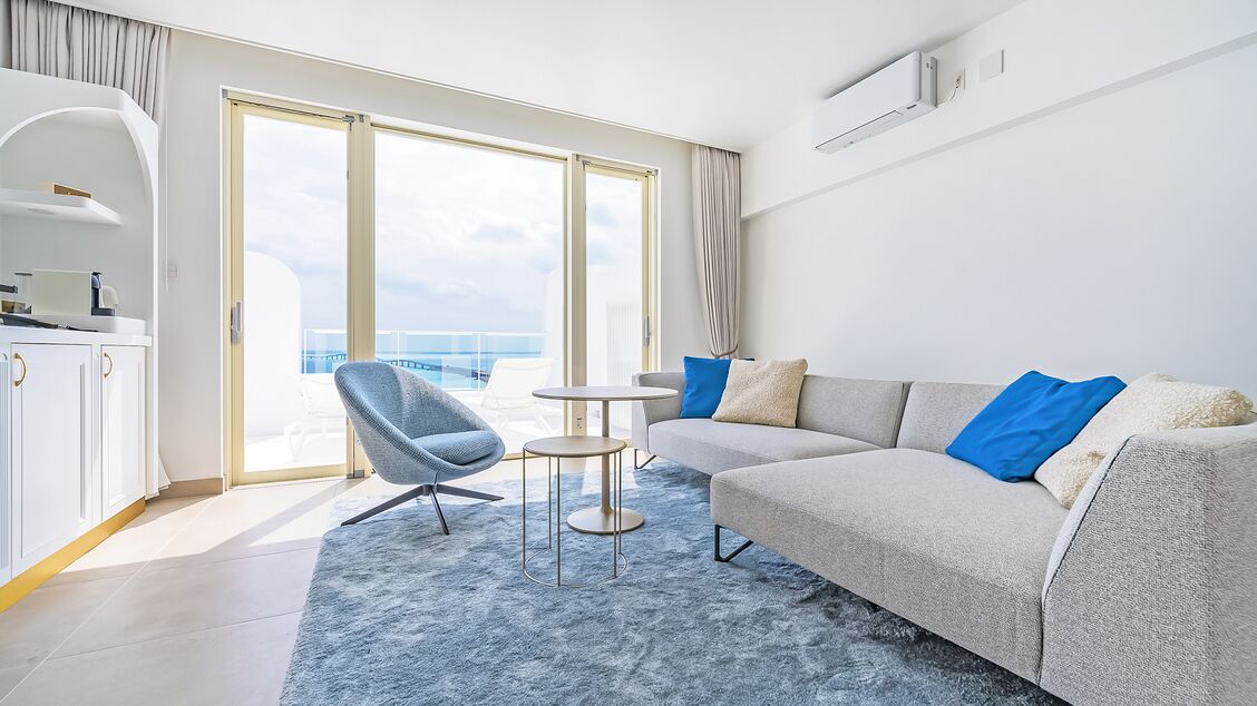 Een moderne hotelkamer met een bank, fauteuil en een klein tafeltje.