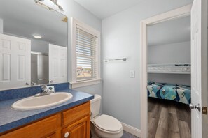 Une salle de bain avec un lavabo, un miroir et des toilettes.