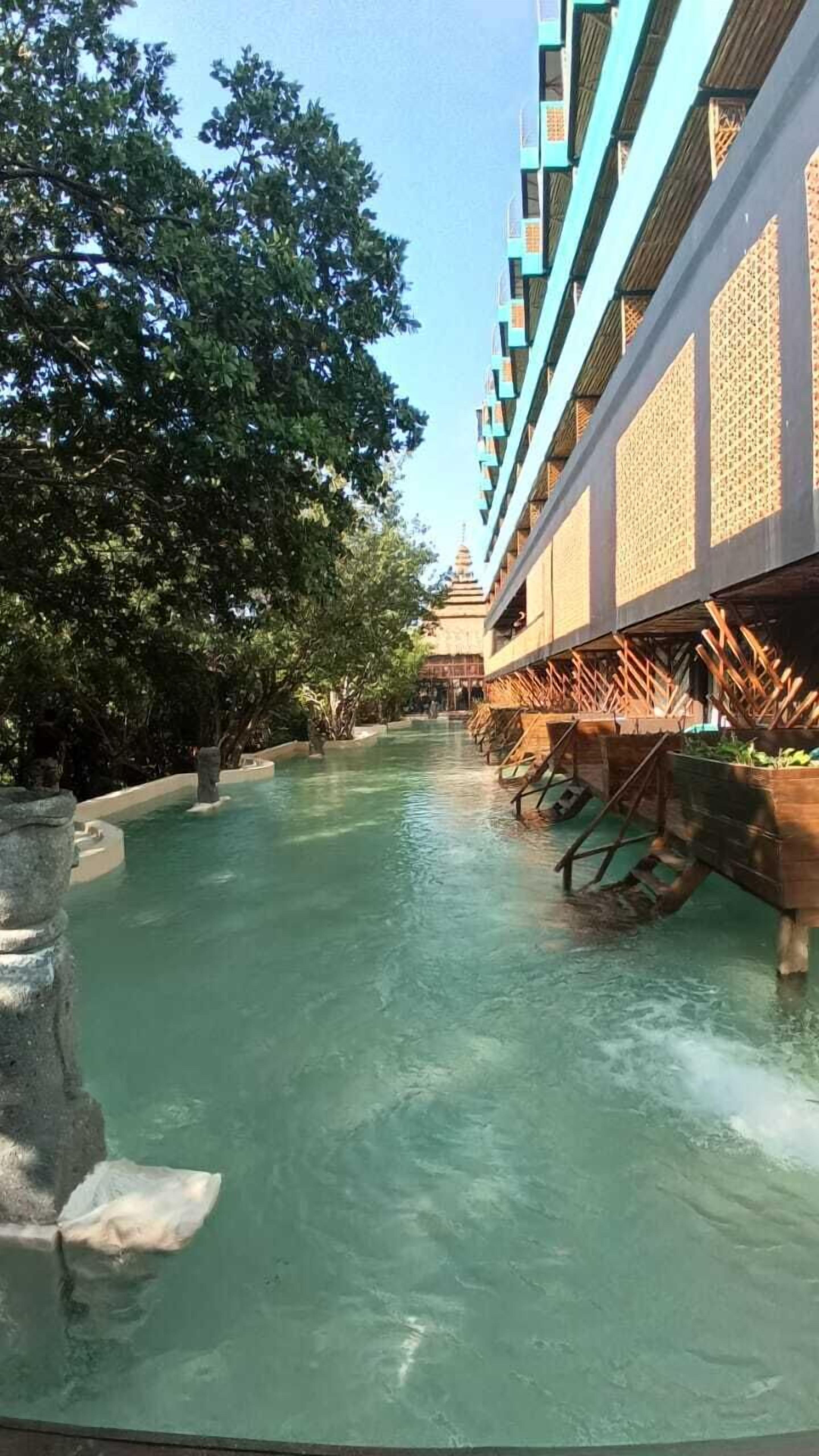 A water channel with a building on one side and trees on the other.