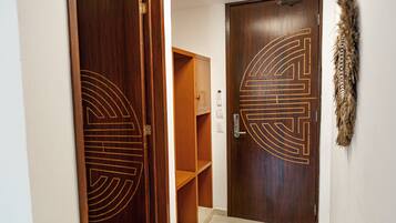 A wooden door with a geometric design, a wooden shelf unit, and a wall-mounted decorative item.