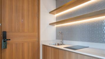 A modern kitchen with wooden cabinets, a stainless steel sink, and under-cabinet lighting.