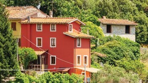 A red building with a tiled roof, surrounded by greenery and other buildings. - Beautiful private villa with private pool, WIFI, pets allowed and panoramic view, close to Viare... (Gombitelli)