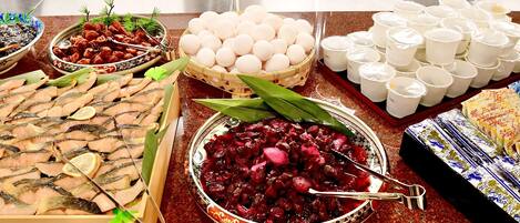 A buffet table with various dishes including fish, eggs, and a salad.