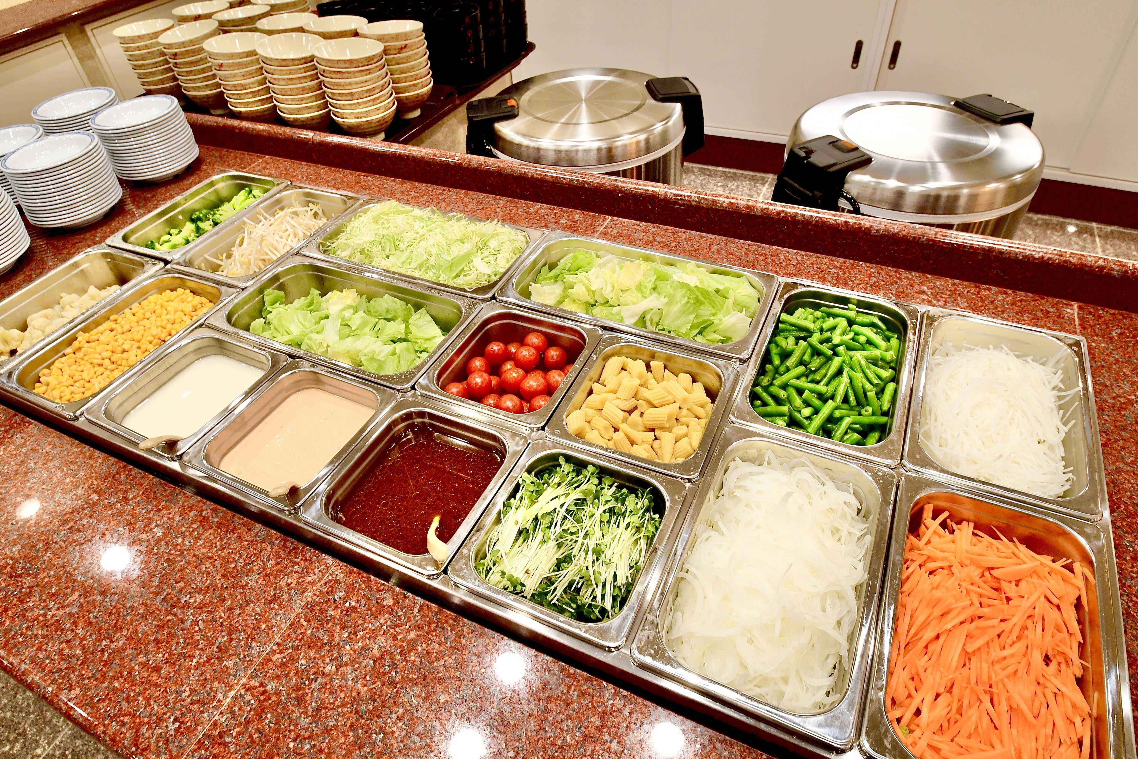 A buffet with various food items and condiments.