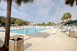 A pool area with lounge chairs and a water slide. - The Saltwater Cottage-Golf Cart & Linens Included in Ocean Lakes (Myrtle Beach)