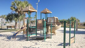 A playground with climbing structures, slides, and a sand area. - The Saltwater Cottage-Golf Cart & Linens Included in Ocean Lakes (Myrtle Beach)