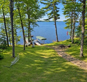 A lakeside campsite with a hammock, picnic table, and a view of the water.