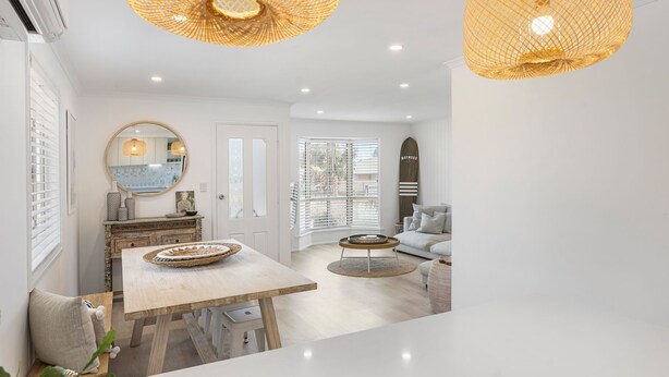 A modern interior with a dining area, a sofa, and a large window with blinds. - Our Little White House -74  Padman Crescent, Middleton (Middleton)