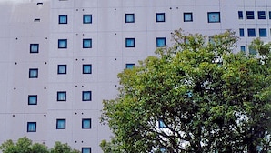 Een meerhoog gebouw met een opvallend bord bovenaan.