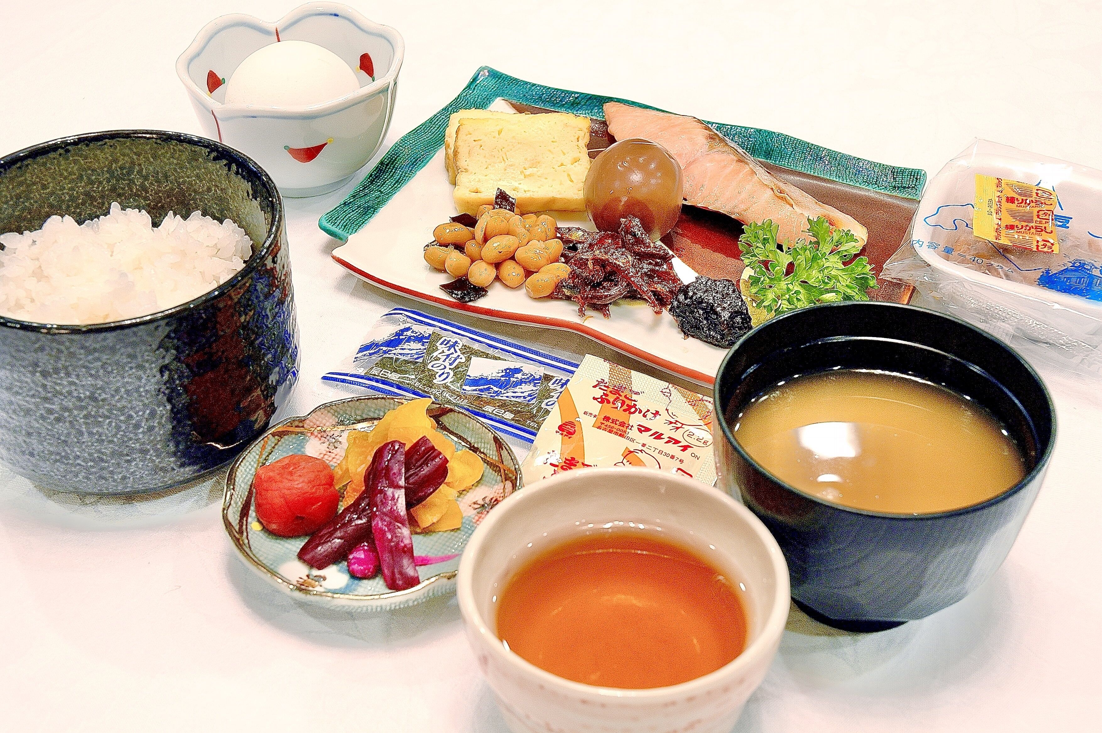 Uma mesa com diversos alimentos, incluindo arroz, peixe e legumes.