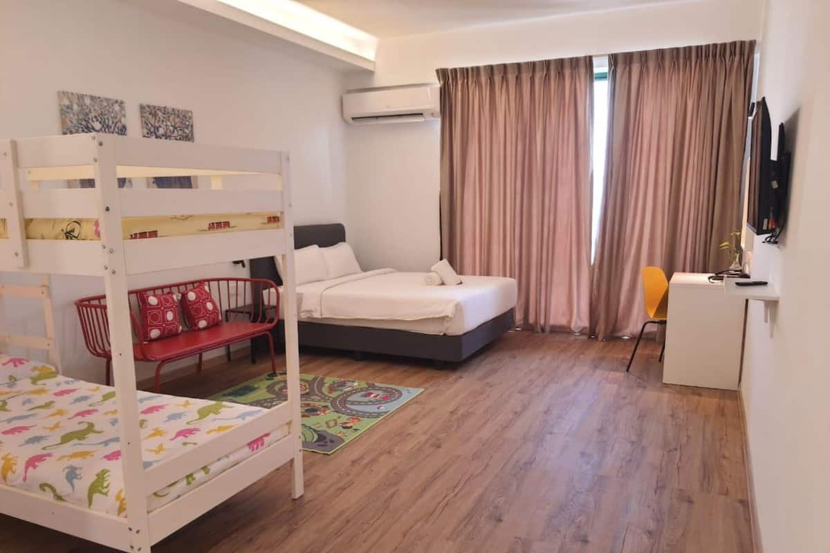 Ein Zimmer mit Etagenbett, Schreibtisch, Stuhl, einem Bett und einem Fernseher.