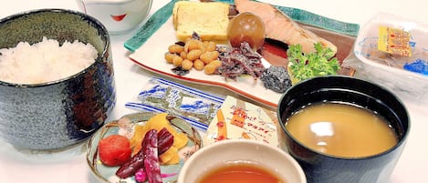 A table with various food items including rice, fish, and vegetables.