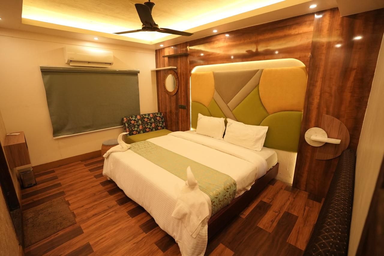 Une chambre à coucher comprenant un lit, un ventilateur de plafond, un appareil de climatisation, une fenêtre, une table de chevet et une horloge fixée au mur.