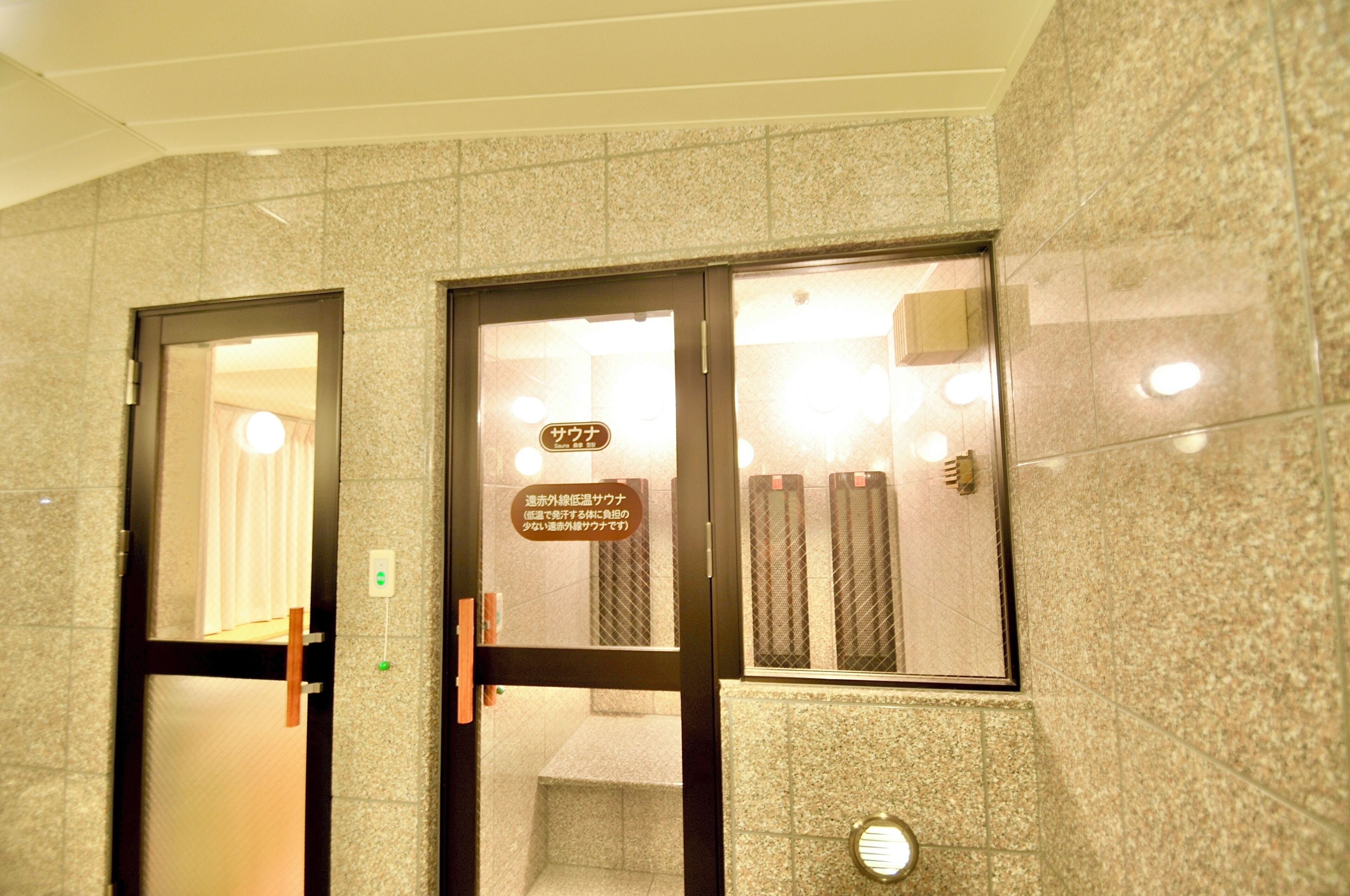 Entrada de hotel con un cartel que indica la existencia de una sauna.