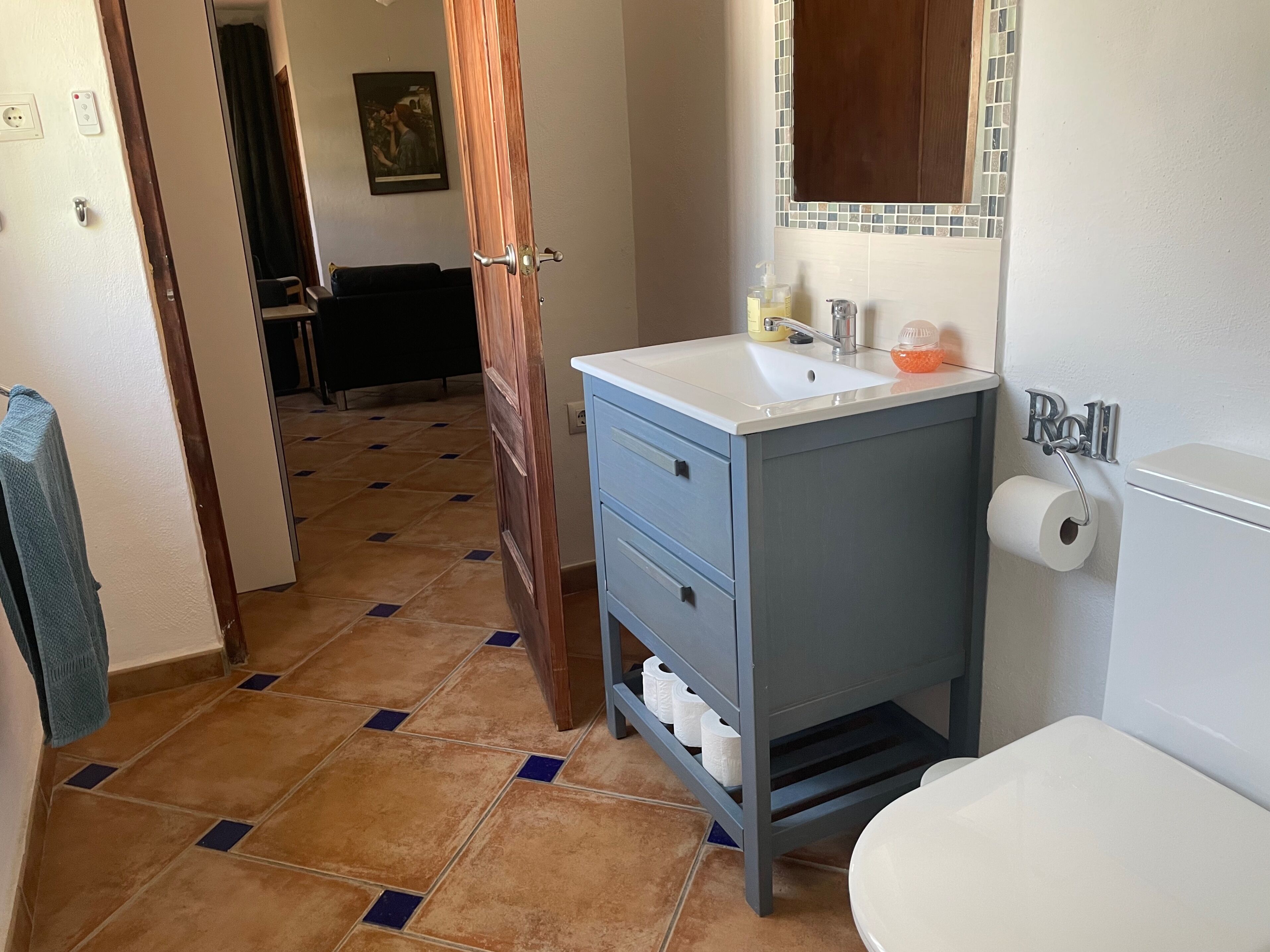 A bathroom with a sink, toilet, and shower area.