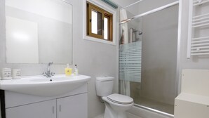 A bathroom with a white sink, toilet, and shower. - Captivating 2-Bed House (Larnaca Agios Theodoros)
