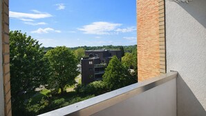 A balcony with a view of a building and trees.