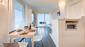 A modern kitchen with a built-in microwave, dining table set for two, and a view to the outside. - Casa Oleandri Shared Pool & Lake View, Toscolano Maderno, Italy (Toscolano Maderno)