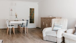 Una sala de estar moderna con comedor, un mueble de madera y un sillón acogedor.
