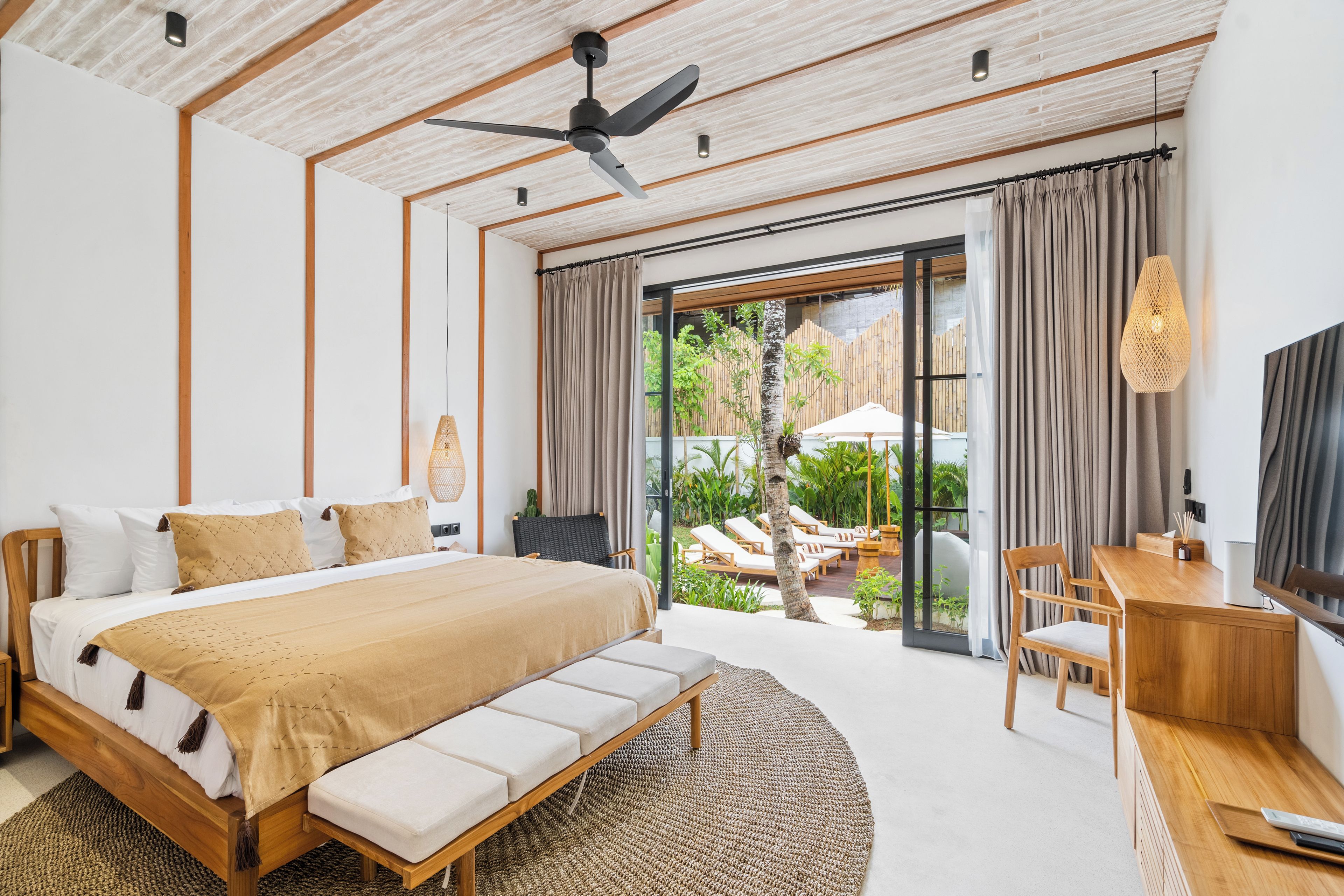 Un dormitorio moderno con una cama grande, un escritorio y vistas a un espacio exterior.