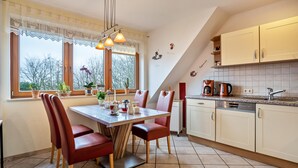 Une cuisine équipée d’une table à manger, de chaises et d’une machine à café.