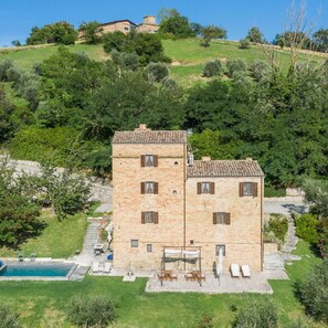 A two-story stone building with a swimming pool and outdoor seating area. - Casatorre 6 2 Emma Villas (Saludecio)