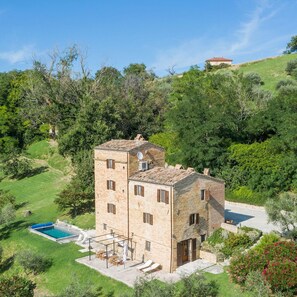 A stone building with a pool and outdoor seating. - Casatorre 6 2 Emma Villas (Saludecio)