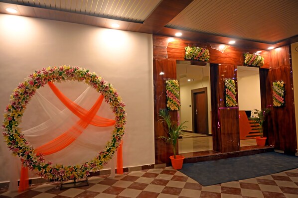A reception area with a floral archway, wooden paneling, and a checkered floor.